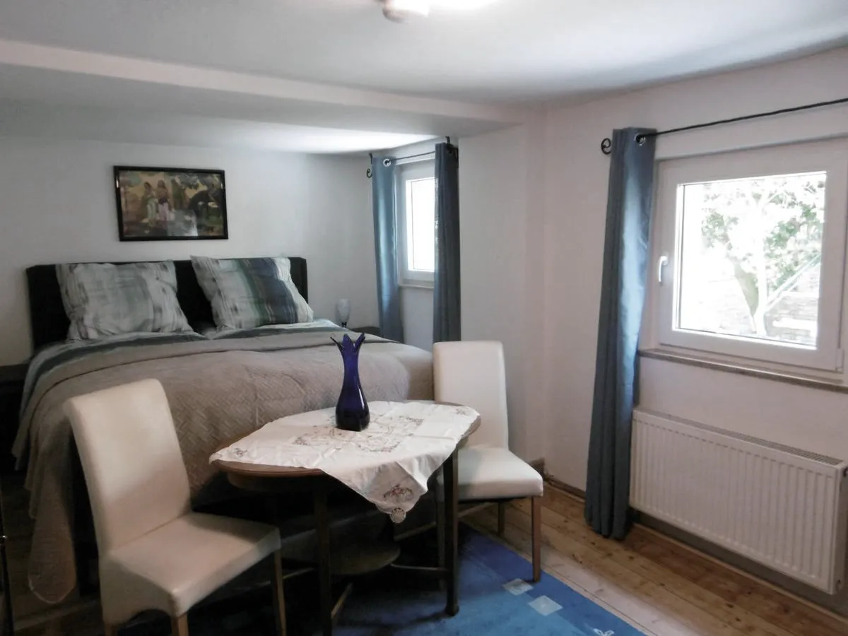 Hauptschlafzimmer mit Doppelbett, blauem Teppich und Gemälde über dem Bett